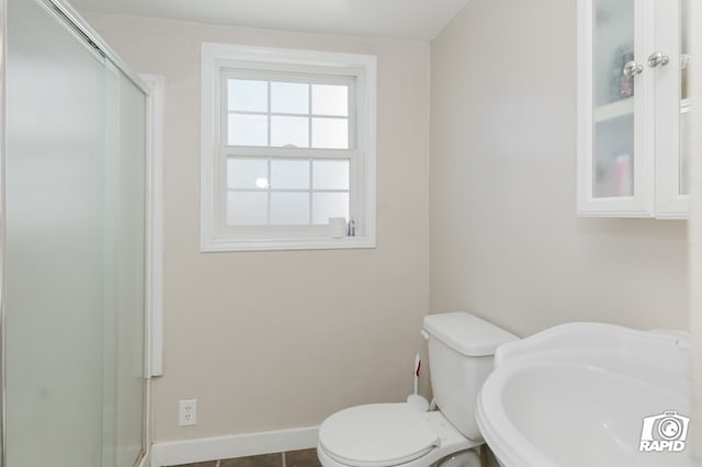 full bath featuring baseboards, a sink, toilet, and a shower stall