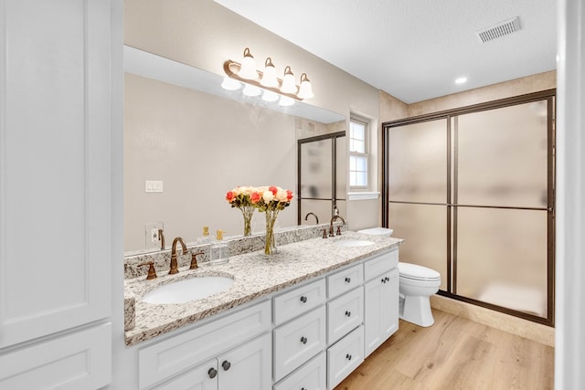 10606 E County Rd 104, Midland, TX 79706 - full bath featuring wood finished floors, double vanity, and a stall shower