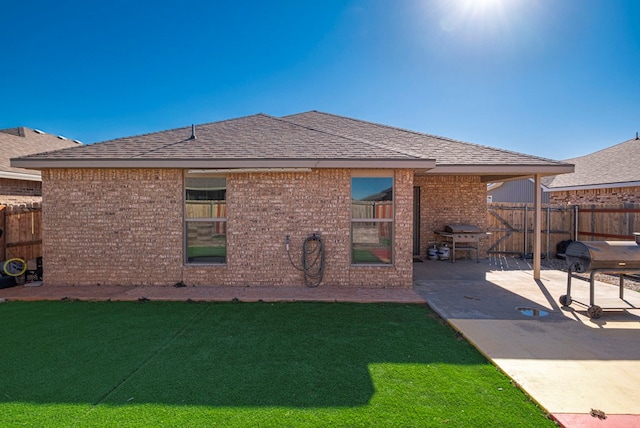 rear view of property featuring a patio area and a lawn