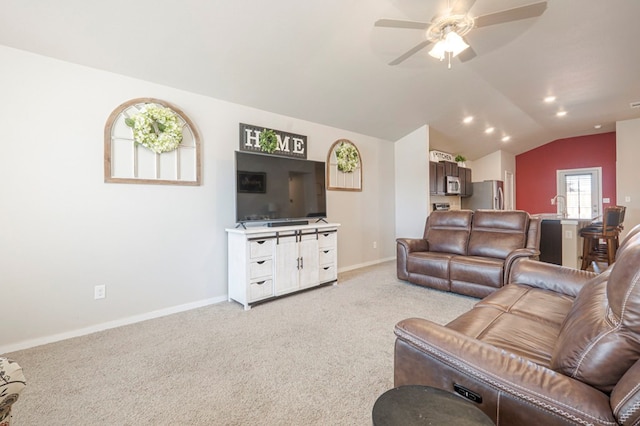 carpeted living room featuring vaulted ceiling, sink, and ceiling fan