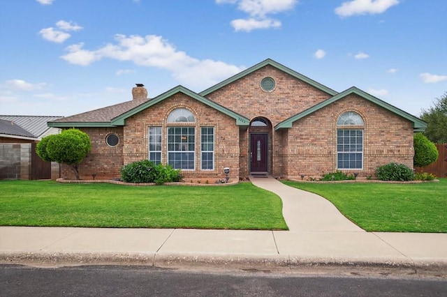 3834 Hyden Dr, Odessa, TX 79762 - view of front of house featuring brick siding, a front yard, and a chimney