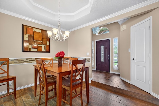 3834 Hyden Dr, Odessa, TX 79762 - dining space with dark wood-style floors, a raised ceiling, a chandelier, ornamental molding, and baseboards