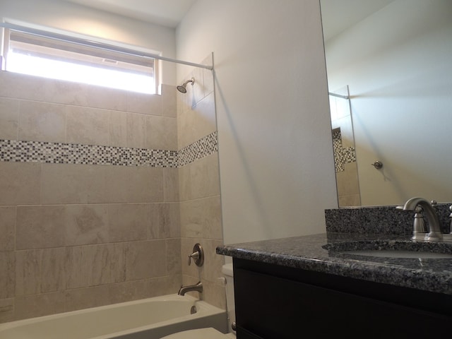 full bathroom with vanity, tiled shower / bath combo, and toilet