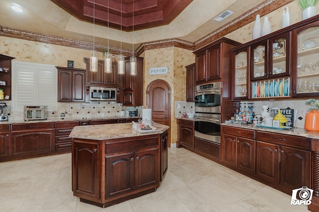 540 SE Loop 338, Odessa, TX 79766 - kitchen with appliances with stainless steel finishes, backsplash, hanging light fixtures, a center island, and glass insert cabinets