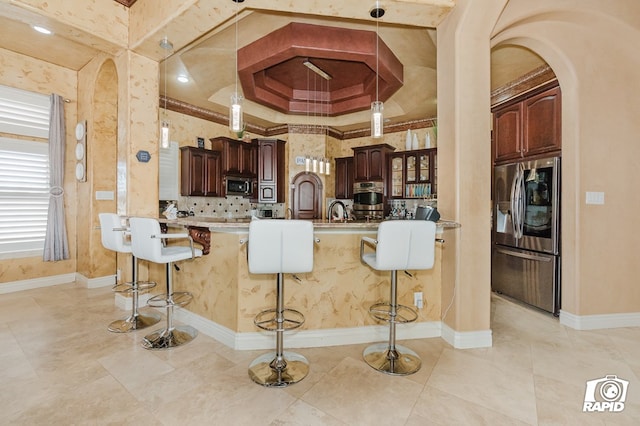 540 SE Loop 338, Odessa, TX 79766 - kitchen featuring appliances with stainless steel finishes, arched walkways, a kitchen bar, light countertops, and hanging light fixtures