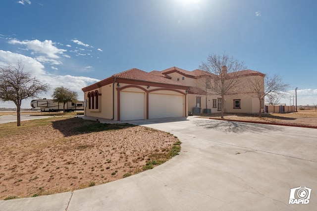 540 SE Loop 338, Odessa, TX 79766 - mediterranean / spanish-style house with a garage, driveway, stucco siding, and a tiled roof