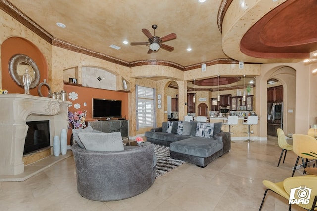 540 SE Loop 338, Odessa, TX 79766 - living room featuring a ceiling fan, crown molding, arched walkways, and a glass covered fireplace