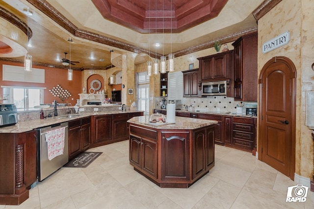 540 SE Loop 338, Odessa, TX 79766 - kitchen featuring appliances with stainless steel finishes, a tray ceiling, a ceiling fan, decorative light fixtures, and a center island
