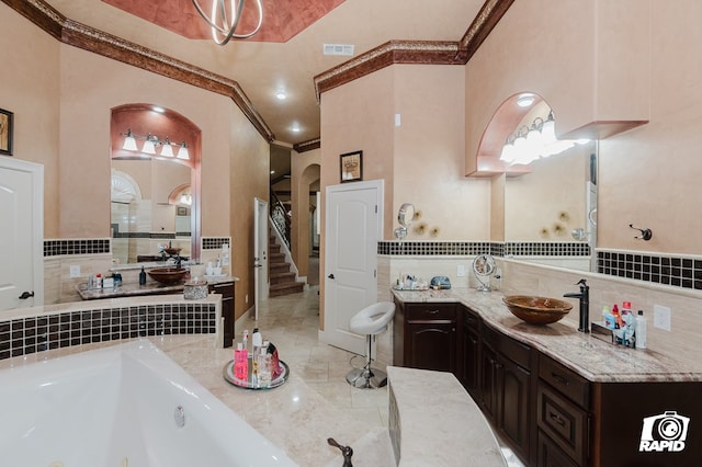 540 SE Loop 338, Odessa, TX 79766 - full bath with ornamental molding, a tub with jets, tile walls, vanity, and wainscoting