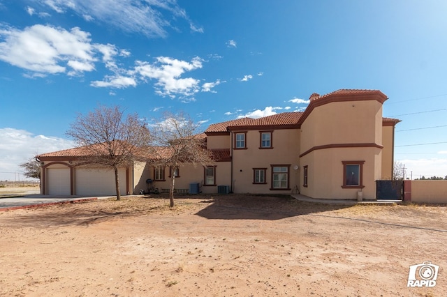 540 SE Loop 338, Odessa, TX 79766 - rear view of property with a tiled roof, stucco siding, concrete driveway, and an attached garage