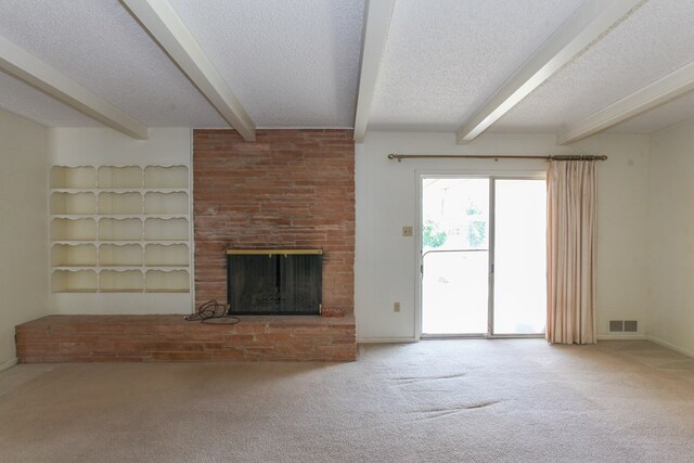 2608 E 24th St, Big Spring, TX 79720 - unfurnished living room with beamed ceiling, carpet flooring, a textured ceiling, and a fireplace