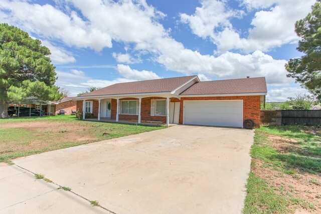 2608 E 24th St, Big Spring, TX 79720 - ranch-style home featuring covered porch, a garage, brick siding, and driveway