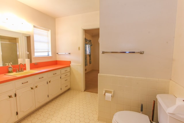 2608 E 24th St, Big Spring, TX 79720 - bathroom with tile walls, vanity, a wainscoted wall, a stall shower, and tile patterned floors
