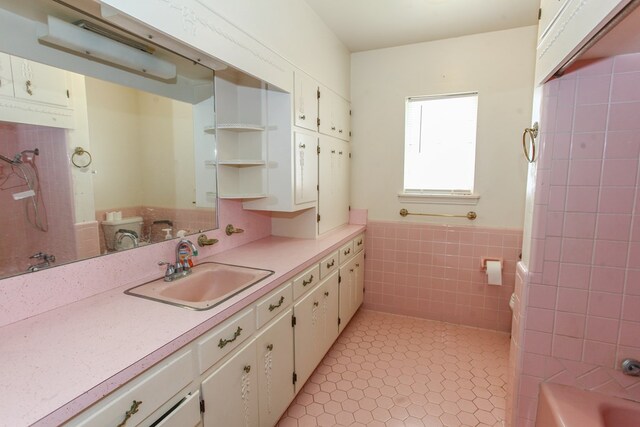 2608 E 24th St, Big Spring, TX 79720 - kitchen featuring light countertops, tile walls, wainscoting, light tile patterned floors, and open shelves