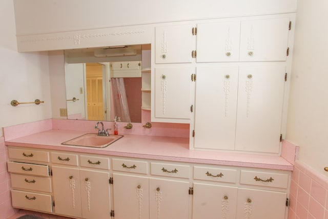 2608 E 24th St, Big Spring, TX 79720 - bathroom featuring vanity, a wainscoted wall, and tile walls