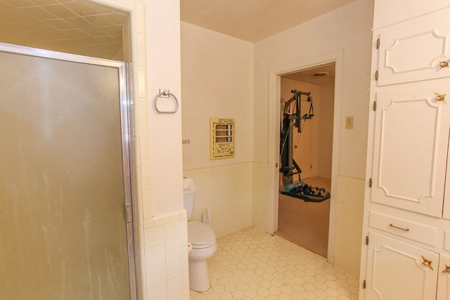 2608 E 24th St, Big Spring, TX 79720 - full bathroom with a shower stall, wainscoting, tile patterned floors, heating unit, and tile walls