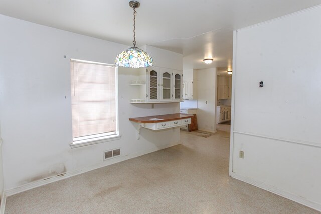 2608 E 24th St, Big Spring, TX 79720 - kitchen with white cabinetry, open shelves, light carpet, pendant lighting, and glass insert cabinets