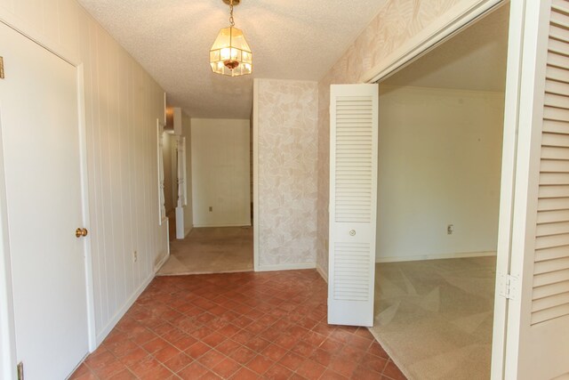 2608 E 24th St, Big Spring, TX 79720 - corridor with a textured ceiling, wallpapered walls, and dark colored carpet