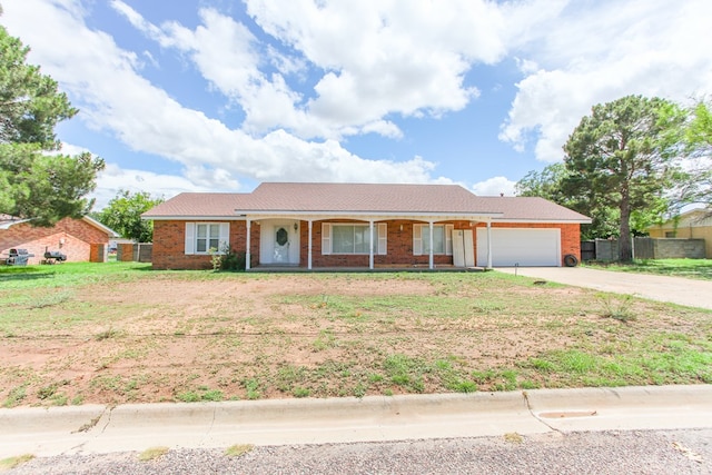 2608 E 24th St, Big Spring, TX 79720 - ranch-style house with covered porch, a garage, concrete driveway, and brick siding