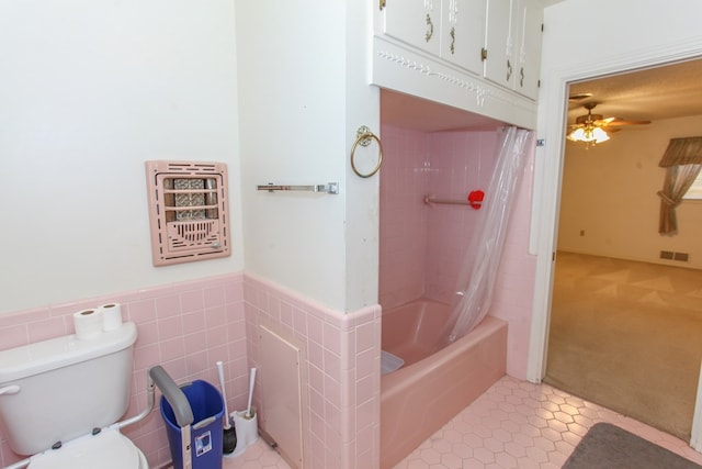 2608 E 24th St, Big Spring, TX 79720 - bathroom with ceiling fan, shower / bathtub combination with curtain, tile patterned flooring, and a wainscoted wall