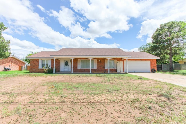 2608 E 24th St, Big Spring, TX 79720 - ranch-style house with a porch, a garage, driveway, and brick siding