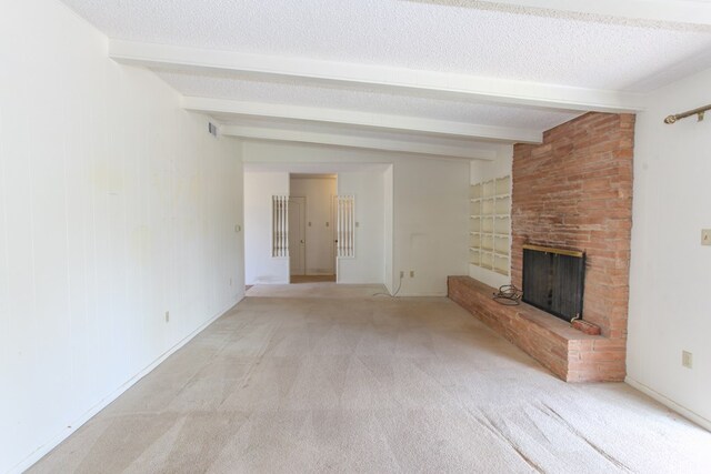 2608 E 24th St, Big Spring, TX 79720 - unfurnished living room with beamed ceiling, a fireplace, carpet floors, and a textured ceiling