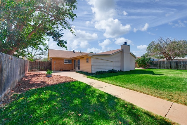 rear view of property featuring a patio and a yard