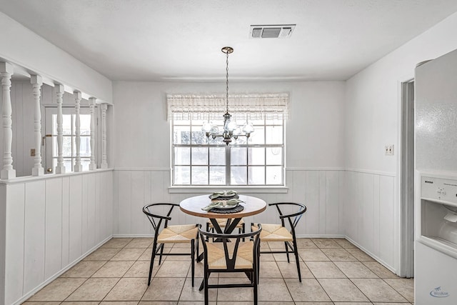 tiled dining room featuring a chandelier and a textured ceiling