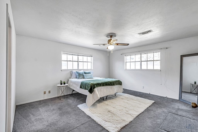 carpeted bedroom featuring a textured ceiling and ceiling fan