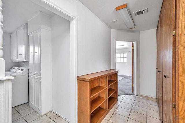 hallway with washer and clothes dryer and light tile patterned floors