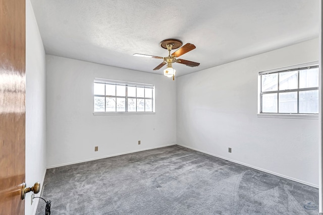 carpeted spare room featuring ceiling fan and a textured ceiling