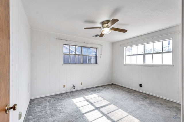 unfurnished room featuring carpet floors, a wealth of natural light, and ceiling fan