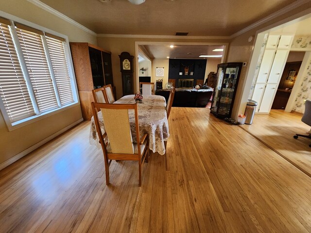 dining space featuring light hardwood / wood-style floors and ornamental molding