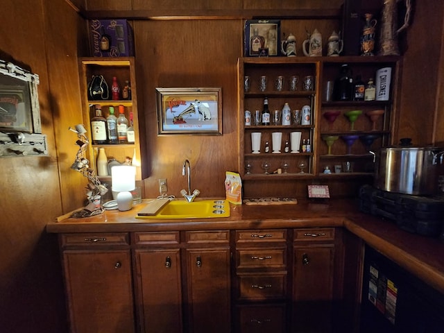 bar featuring wood walls and sink