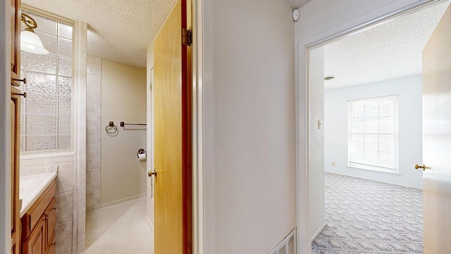 309 Edgewood Dr, Midland, TX 79703 - corridor featuring a textured ceiling and light colored carpet