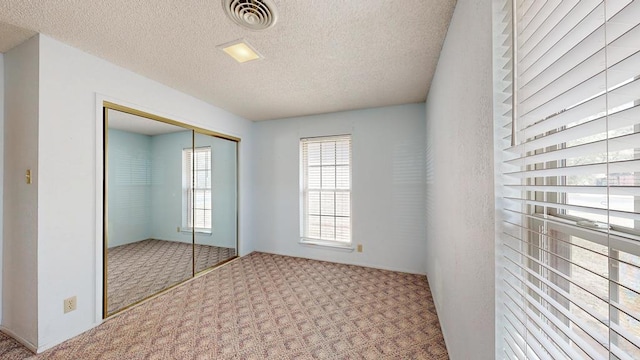 309 Edgewood Dr, Midland, TX 79703 - unfurnished bedroom with carpet floors, a closet, and a textured ceiling
