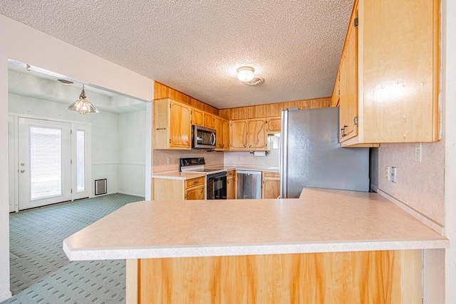 309 Edgewood Dr, Midland, TX 79703 - kitchen with stainless steel appliances, light countertops, a peninsula, a textured ceiling, and carpet flooring