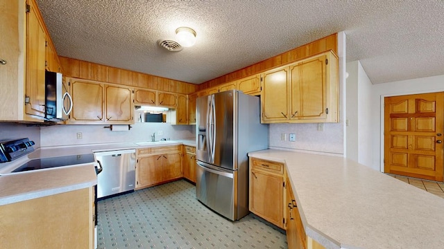 309 Edgewood Dr, Midland, TX 79703 - kitchen with appliances with stainless steel finishes, a textured ceiling, and light countertops