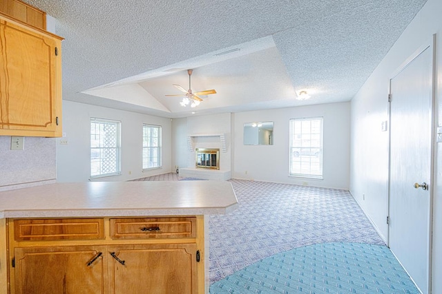 309 Edgewood Dr, Midland, TX 79703 - kitchen featuring open floor plan, light colored carpet, ceiling fan, light countertops, and a peninsula