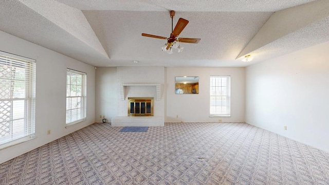 309 Edgewood Dr, Midland, TX 79703 - unfurnished living room featuring carpet flooring, vaulted ceiling, plenty of natural light, ceiling fan, and a textured ceiling