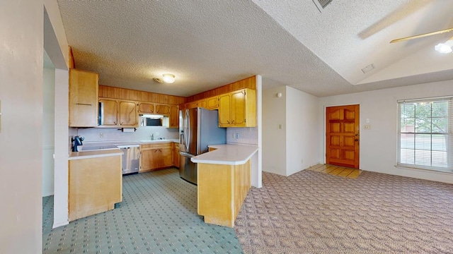309 Edgewood Dr, Midland, TX 79703 - kitchen with appliances with stainless steel finishes, light countertops, light carpet, a peninsula, and vaulted ceiling