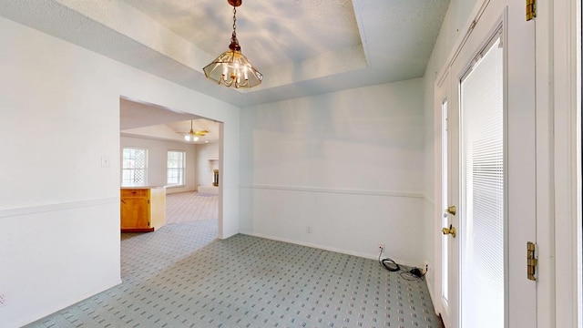 309 Edgewood Dr, Midland, TX 79703 - empty room featuring light carpet, a chandelier, a tray ceiling, and ceiling fan