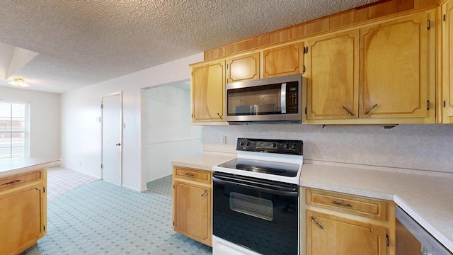309 Edgewood Dr, Midland, TX 79703 - kitchen with appliances with stainless steel finishes, light countertops, a textured ceiling, and light carpet