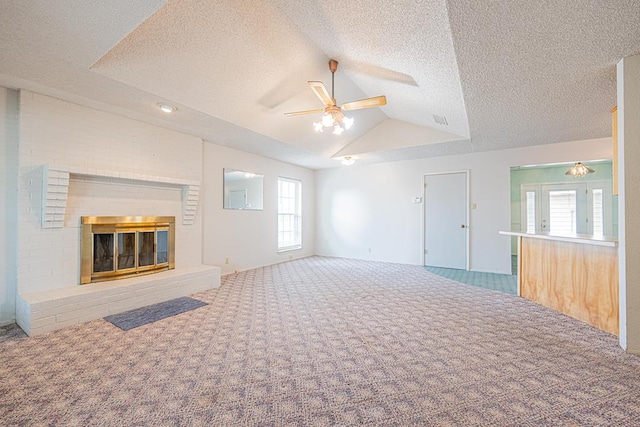 309 Edgewood Dr, Midland, TX 79703 - unfurnished living room featuring carpet flooring, a ceiling fan, vaulted ceiling, a fireplace, and a textured ceiling