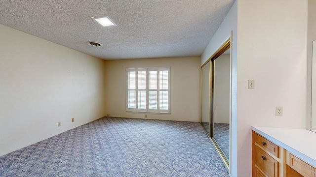 309 Edgewood Dr, Midland, TX 79703 - unfurnished bedroom with light carpet, a textured ceiling, and a closet