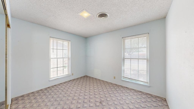 309 Edgewood Dr, Midland, TX 79703 - spare room with healthy amount of natural light, carpet flooring, and a textured ceiling