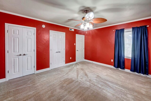 1600 W Kansas, Midland, TX 79701 - unfurnished bedroom featuring two closets, carpet floors, crown molding, baseboards, and a ceiling fan