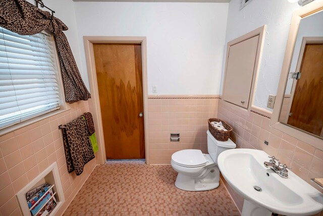 1600 W Kansas, Midland, TX 79701 - bathroom featuring tile walls, a sink, toilet, and wainscoting