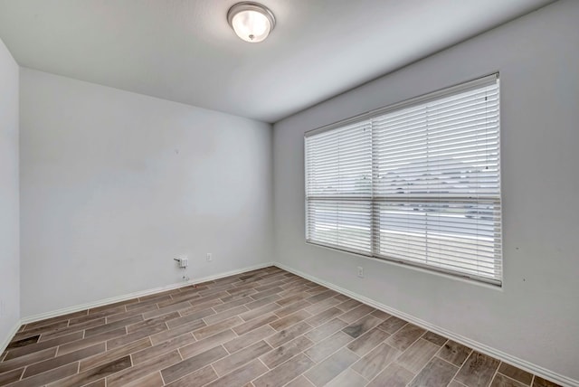 spare room with wood finish floors and baseboards