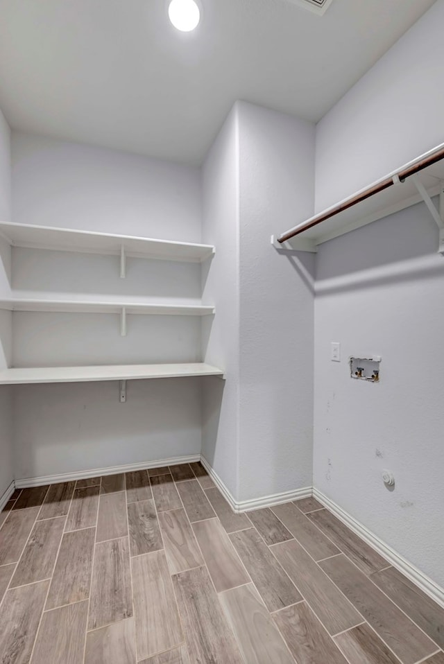 laundry area featuring wood finish floors, gas dryer hookup, and laundry area
